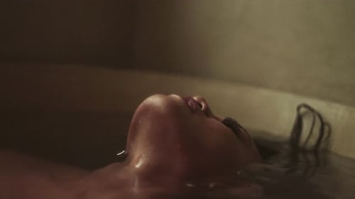 Woman with Wet Hair Relaxes in Bathtub