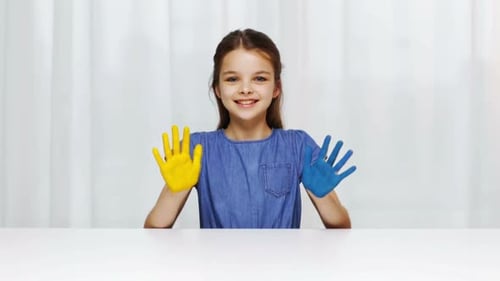Smiling Girl with Painted Hands Showing Support