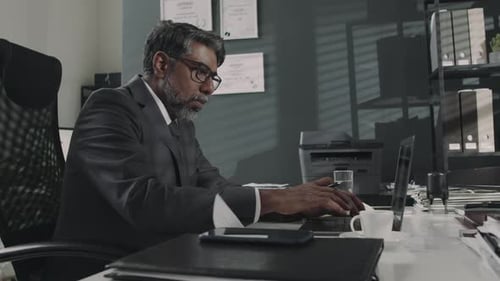 Serious Attorney Checking Information on Laptop While Preparing Contract