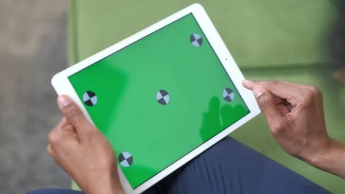 Uma mulher negra com um tablet na mão. Toque em gestos na tela sensível ao toque.