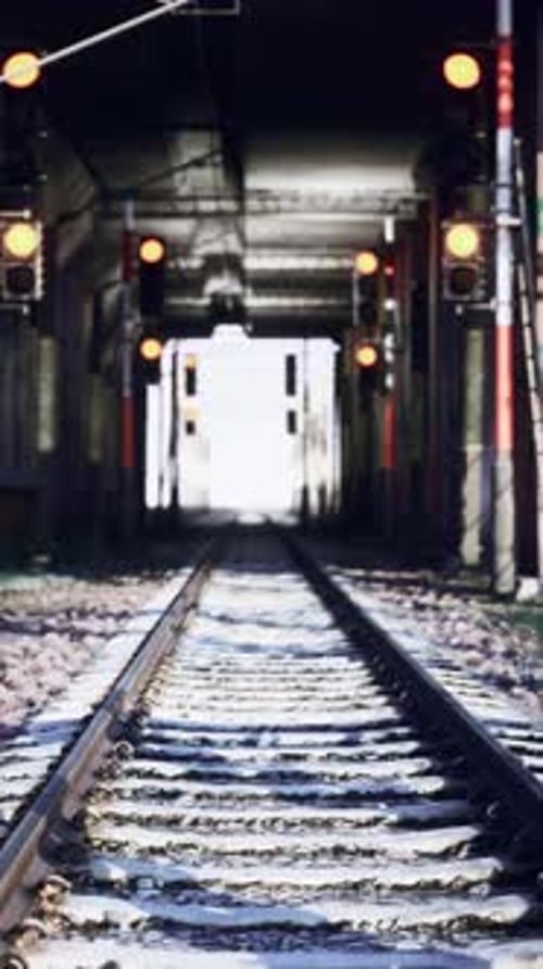 Vía de tren abandonada con luz en la distancia