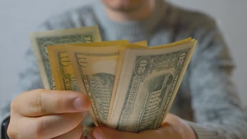 Contando dólares americanos na mão de um homem irreconhecível