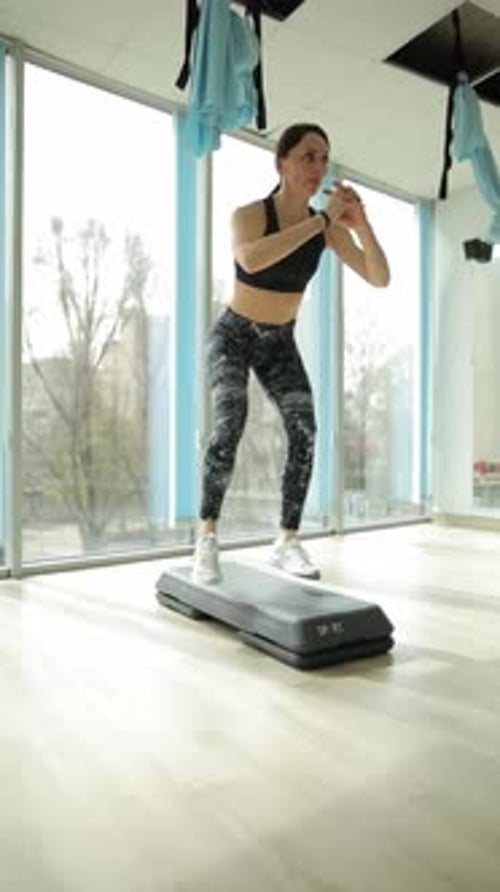Vertical Video Woman Shows Strength and Balance with Squats and Oneleg Stance at the Gym
