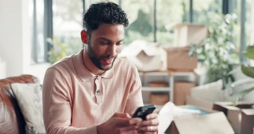 Man Relaxing on Couch Texting on Phone Indoors