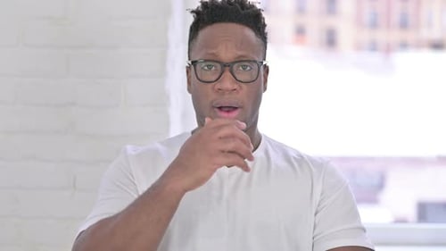 Man Gasps in Surprise with Hand Over Mouth