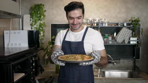 Un influencer masculino está haciendo la pizza en casa.