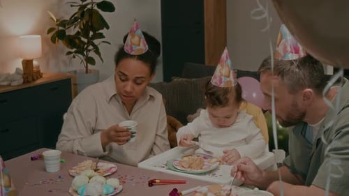 Family Celebrates Birthday with Cake and Balloons