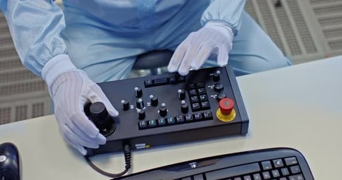 Technician Operating Complex Control Panel in Laboratory