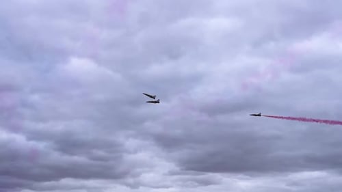 Two Jet Planes Making Way For The KAI T-50 Golden Eagle Jet Plane With Red Contrails To Pass In The