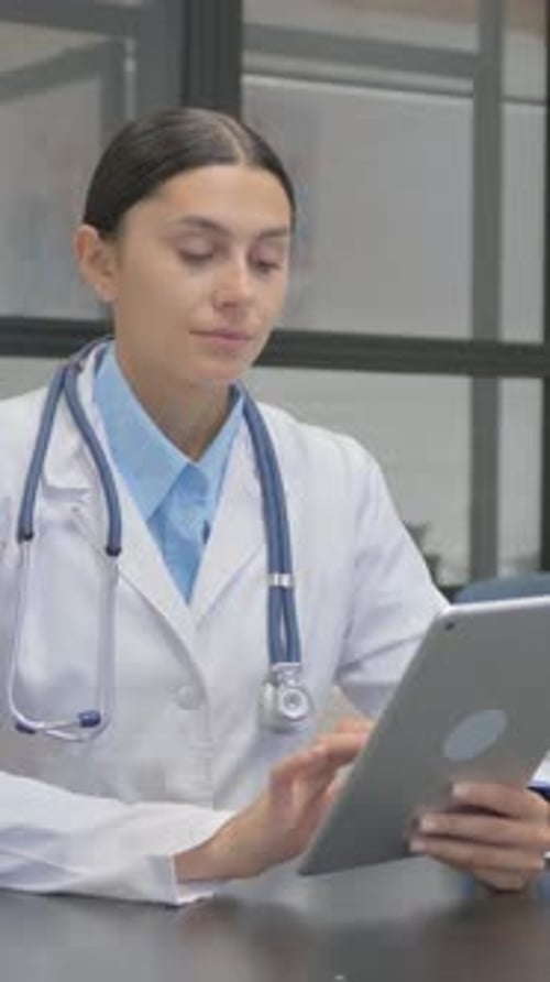 Female Doctor Uses Tablet in Modern Office