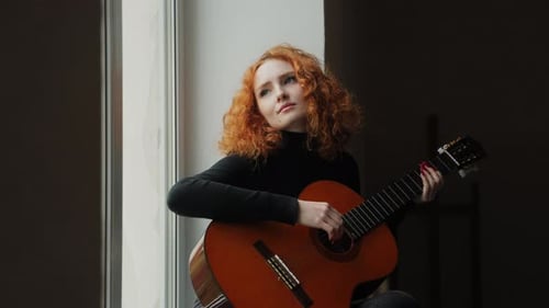 Woman Plays Guitar by Window