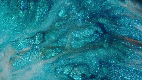 vue de liquides pigmentés bleus étincelants tourbillonnant dans un mouvement fluide et envoûtant