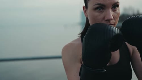 Athletic Woman Training in Boxing Gloves Outdoors