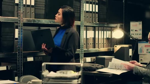 Woman Working on Laptop in Dark Office