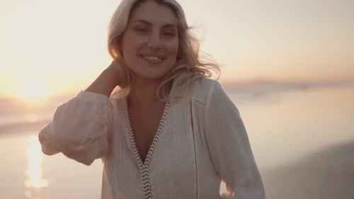 Blond Woman Smiling on Beach at Sunset