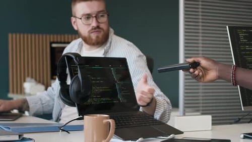 Young Man Sharing Power Bank To His Colleague