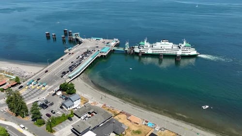 Orbiting drone shot of cars exiting the Whidbey Island ferry and driving onto the mainland.