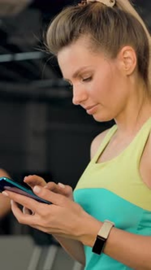Woman Using Smartphone in Gym