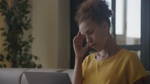 Close Up of a Desperate African American Woman Sitting Indoors in Her Modern Apartment
