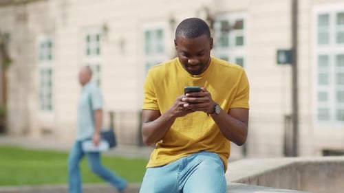Attractive African American Young Attractive Man Using Phone Stand on Street Smile Sunlight Sunset