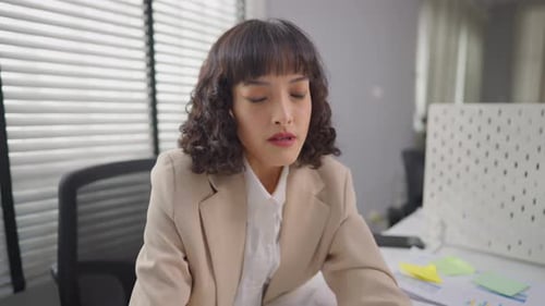 Femme d'affaires asiatique étirant le corps tout en travaillant au bureau.