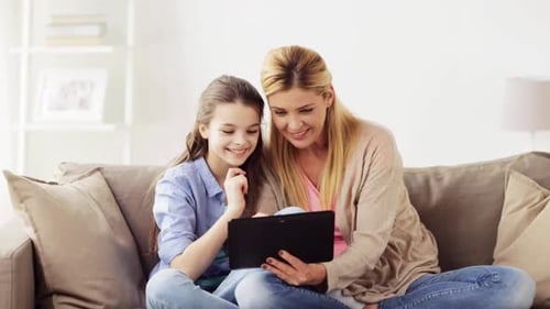Mother and Daughter Smiling at a Tablet Screen