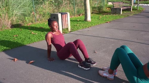 Women exercising together in a park on sunny day