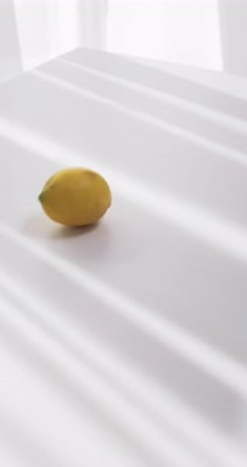 Lemons Falling and Rolling on White Table Slow Motion