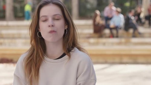 Young Woman Eating Outdoors in an Urban Park