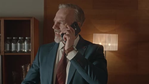 Adult Businessman Talking on Smartphone in Office