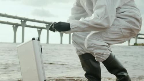Scientist Taking Water Sample on Beach