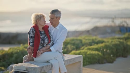 Senior Couple Sharing Intimate Moments on Bench By the Ocean