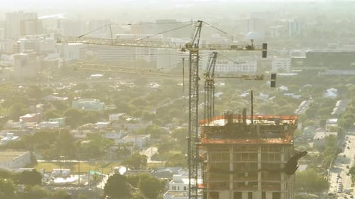 Tower Lifting Cranes at High Residential Apartment Building Construction Site Real Estate