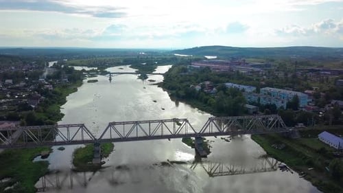 Railway Bridge Spanning Serene River Through Picturesque Countryside
