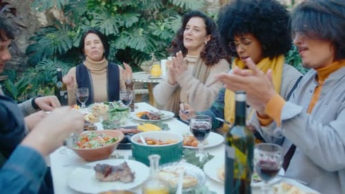 Friends Clapping Hands and Eating Dinner on Outdoor Party