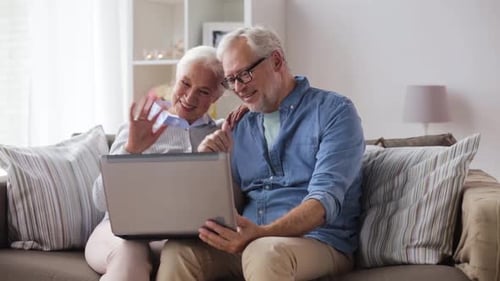 Senior Couple Video Calling Using Laptop At Home
