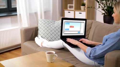 Woman Relaxing on Couch Typing on Laptop