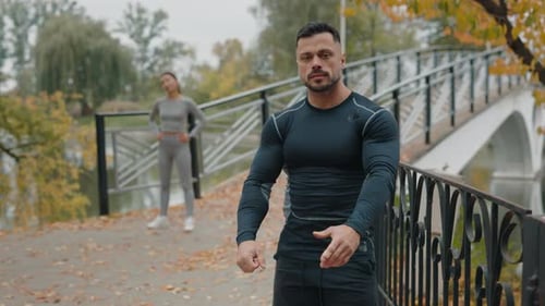 Portrait of the Handsome Man Jogger Looking at Camera After Jogging Resting in the Autumn Park While