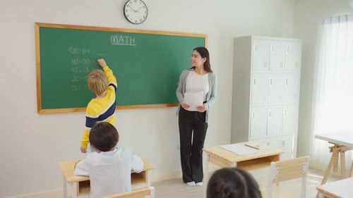 Group of student learn with teacher in classroom at elementary school.