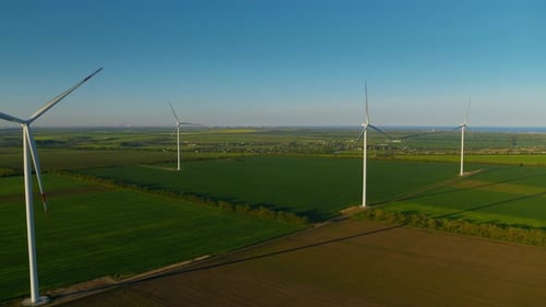 Modern wind turbines rotating in fields generating green energy eco power