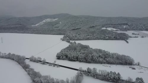 Drone flies high over winter landscape with mountains with snow