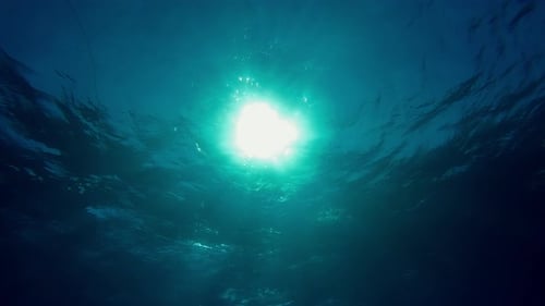 Underwater sunrays in blue depth ocean