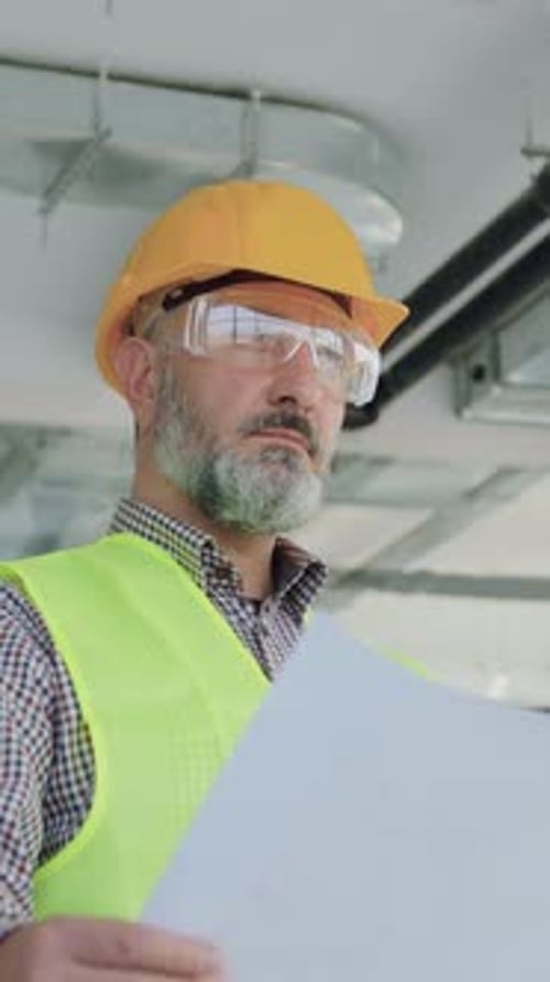 Likable Concentrated Skilled 50Aged Bearded Contractor of Building Company Inspecting Building Works