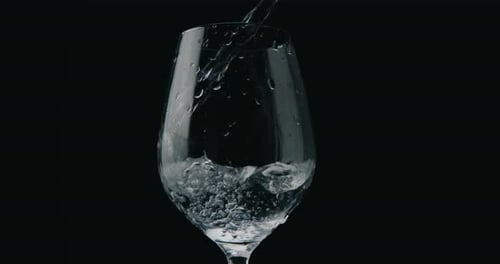 Pouring water in elegant glass in slowmotion