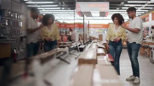 Couple choosing television in electronics store in slow motion