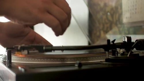 Close up of the stylus getting put onto the record. Men start playing vinyl record. Put the needle o