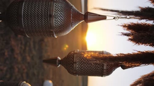 Decorative Moroccan hanging lamps on elopement arch at sunset - Vertical video close up slow motion