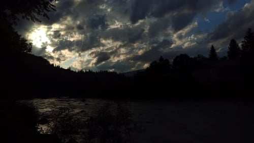 River Flowing Through Silhouette Nature Landscape at Sunset