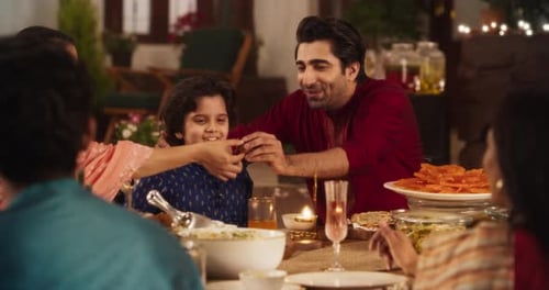 Family Time and Good Happy Memories: Indian Father Feeding his Son and Sharing Traditi