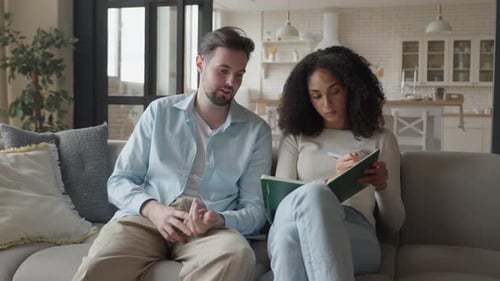 Deux amis discutant d'idées en prenant des notes dans un intérieur confortable